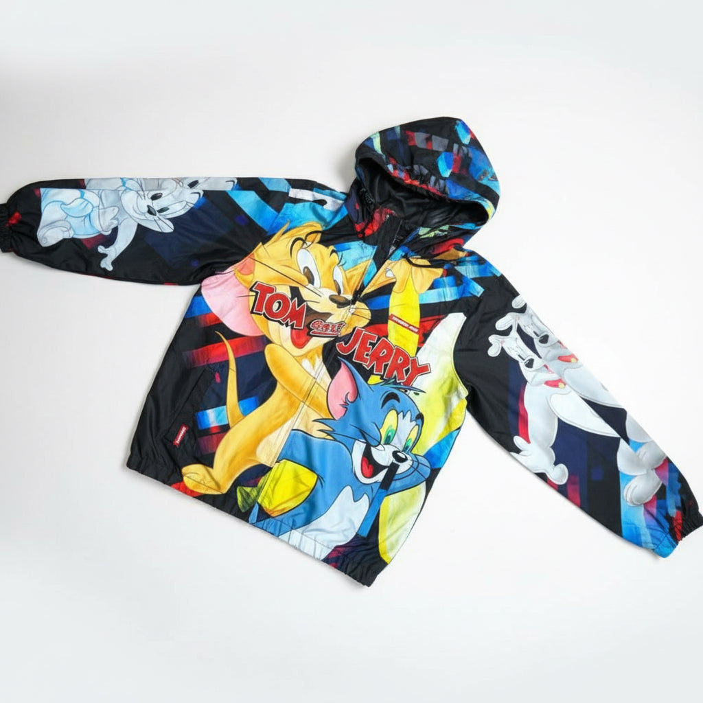 Pili&Pete black nylon windbreaker jacket with a colorful Tom & Jerry print. Features a hood and long sleeves.