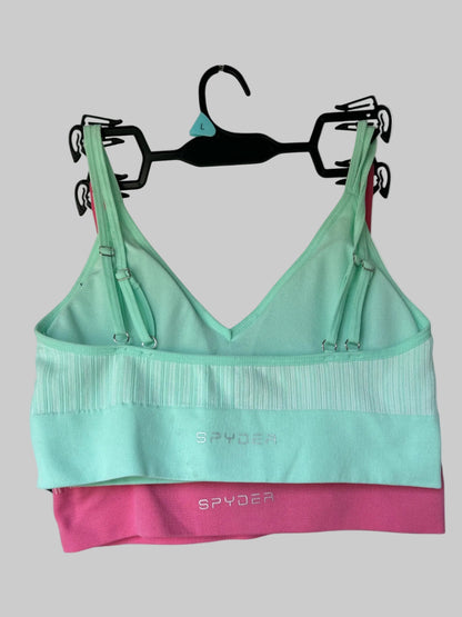 Green and pink sports bra with 'Spyder' branding on a hanger against a white background