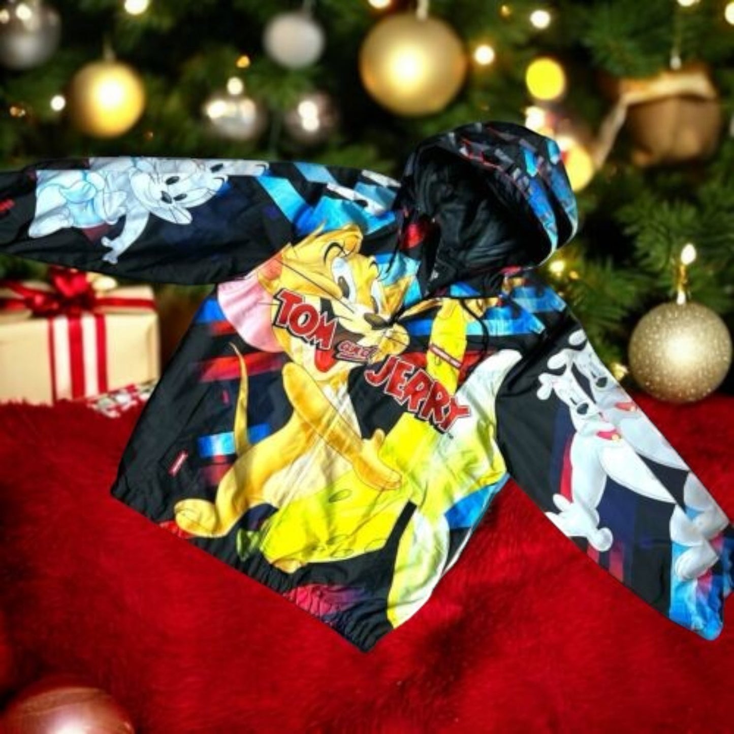 Pili&Pete black nylon windbreaker jacket with a colorful Tom & Jerry print. Features a hood and long sleeves.