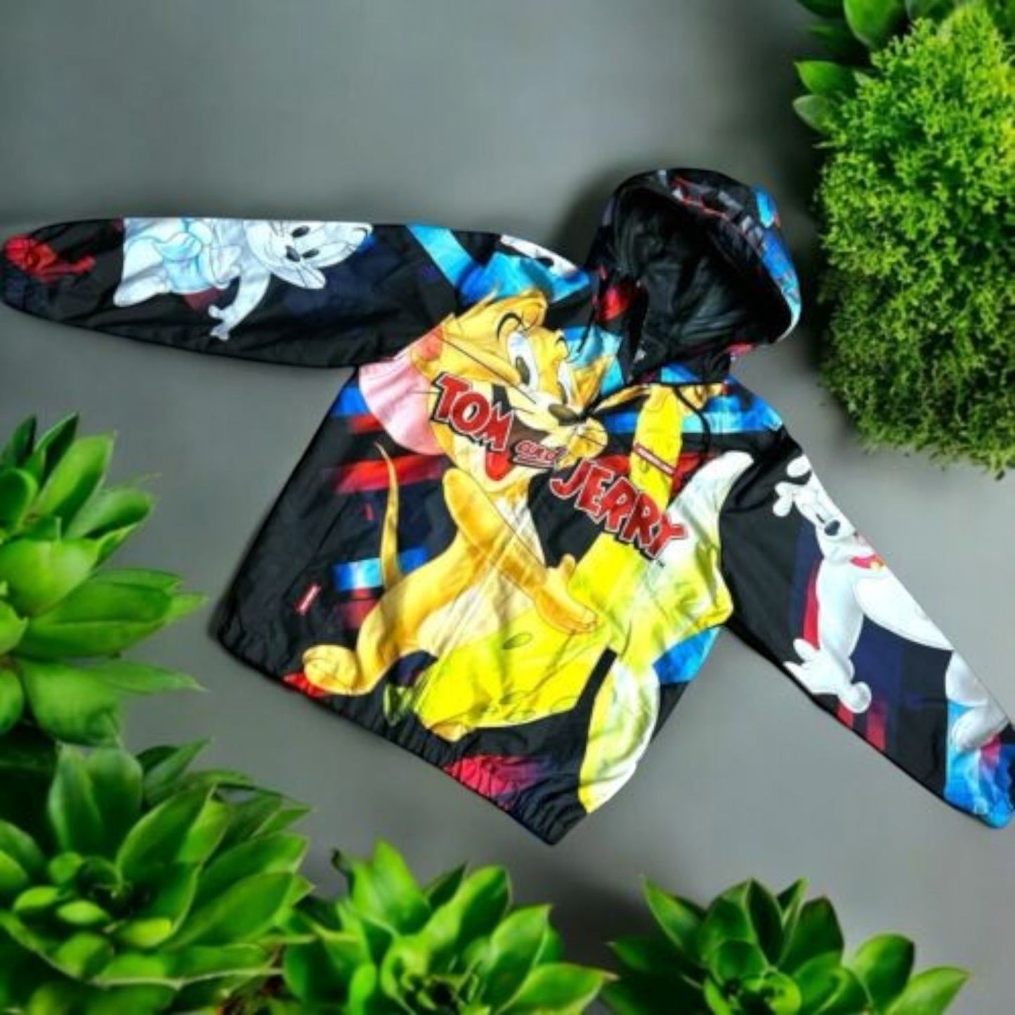 Pili&Pete black nylon windbreaker jacket with a colorful Tom & Jerry print, featuring Tom and Jerry characters and logo.
